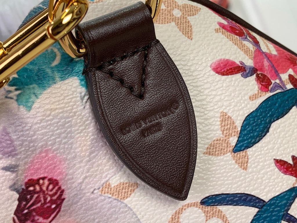 Brown leather strap tab with embossed lettering on floral handbag