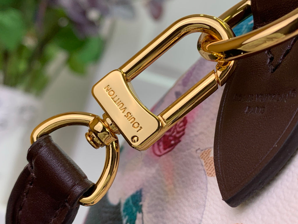 Gold clasp rings and hardware on brown leather strap over floral fabric