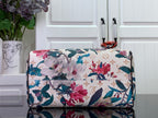 Floral duffel-style handbag with white base and multicolor flowers, brown trim