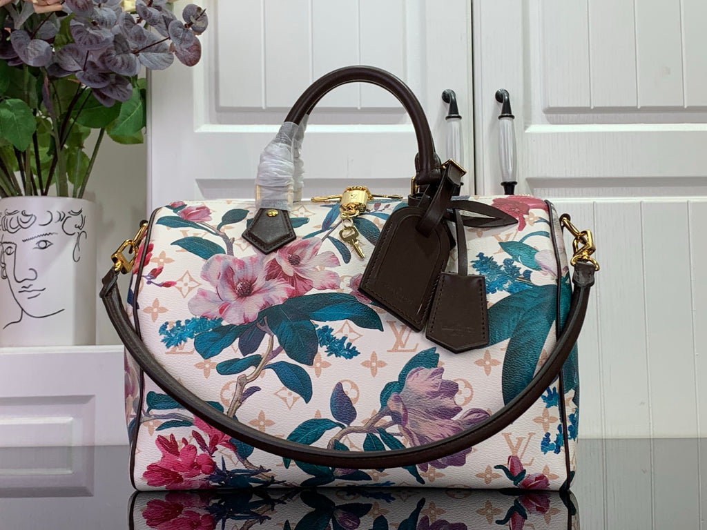 Louis Vuitton handbag with floral print, white base, teal and pink flowers, brown handles