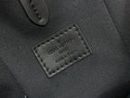 Louis Vuitton leather patch with embossed logo on dark bag