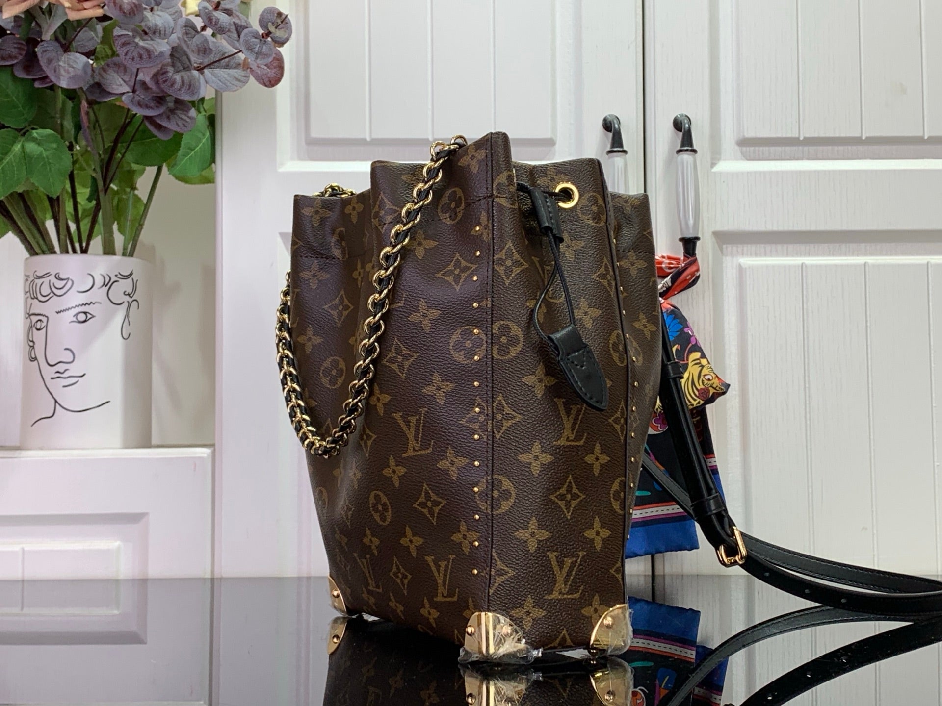 Louis Vuitton monogram bucket bag with crossbody strap, dark brown side view