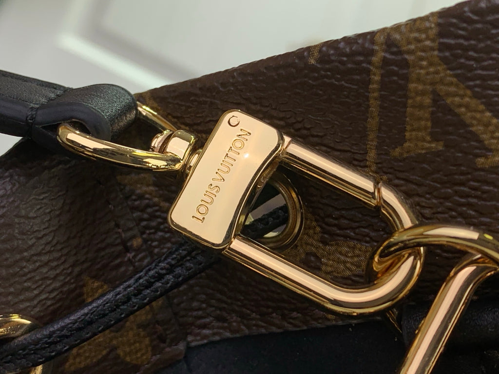 Louis Vuitton gold clasp detail on brown monogram bag, black strap