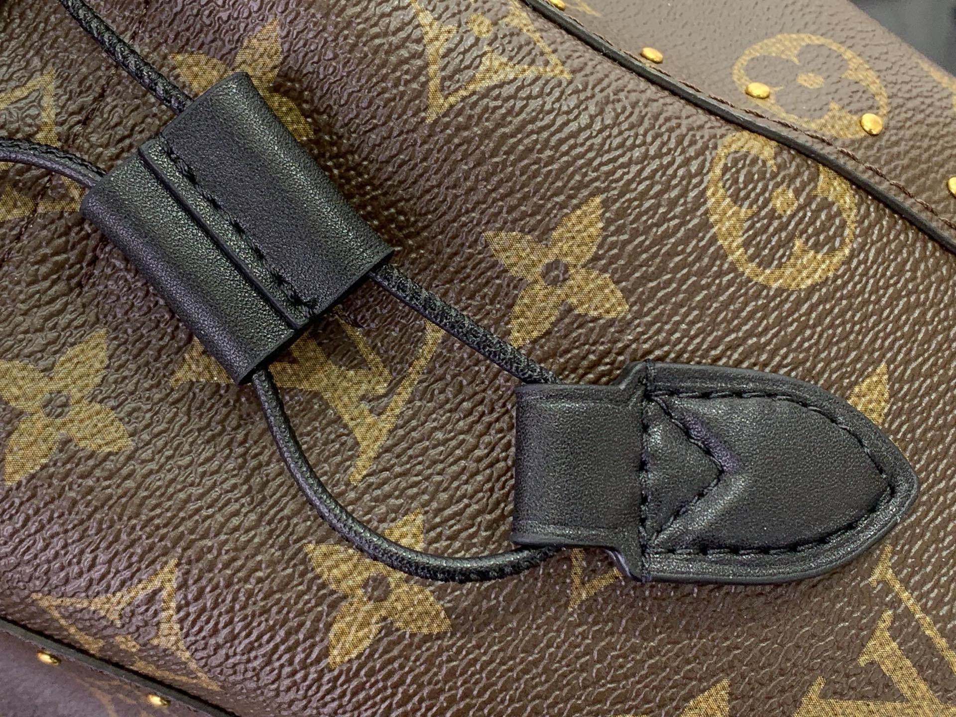 Louis Vuitton monogram bag strap loop with black leather tab and stitching