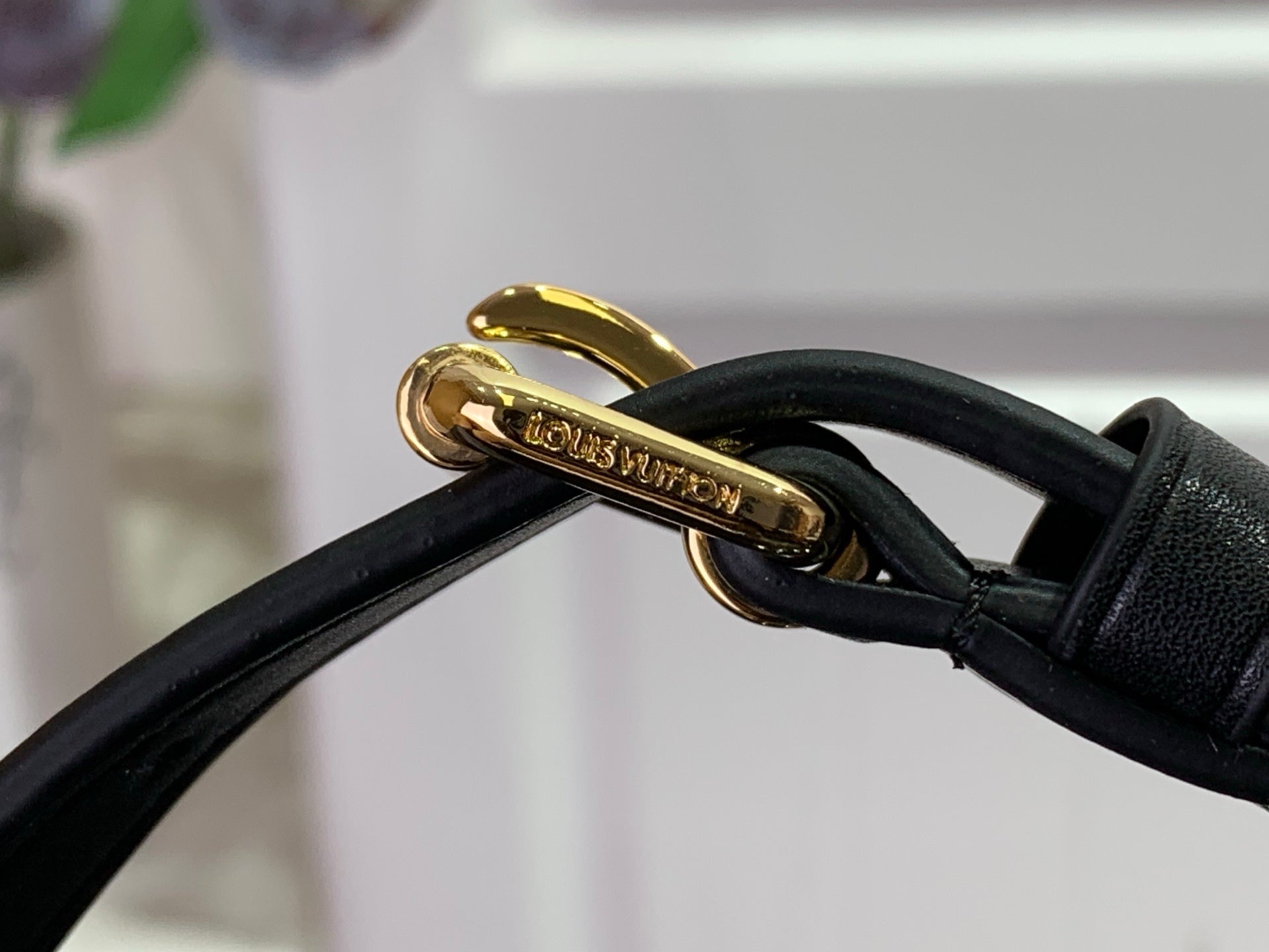 Louis Vuitton bag clasp with black leather strap and gold hardware