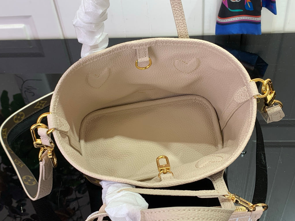 Light beige leather bucket bag with gold hardware and top handle rings
