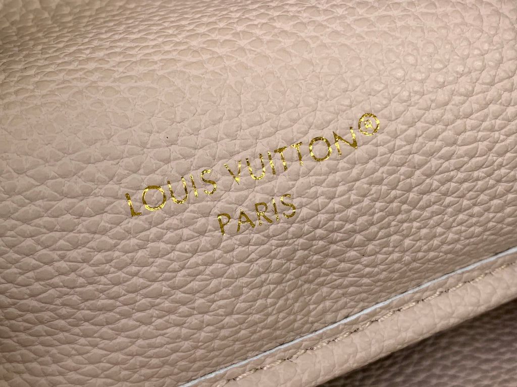 Light beige textured leather Louis Vuitton Paris logo with gold embossed letters