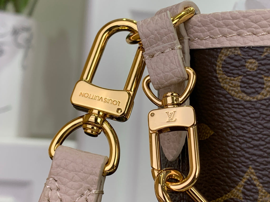 Louis Vuitton monogram tote bag handle close-up with gold hardware and pale leather trim