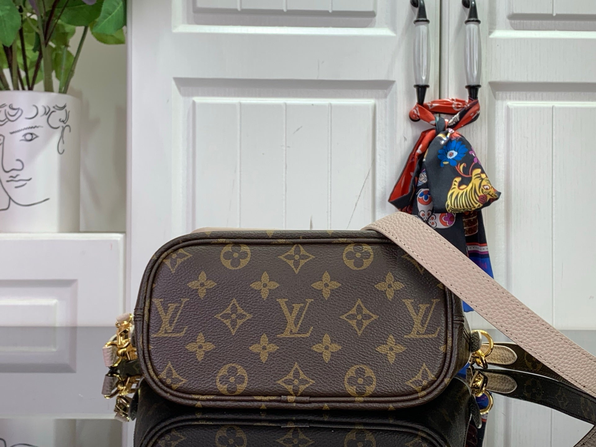 Louis Vuitton monogram crossbody bag with flap, gold hardware, and beige strap