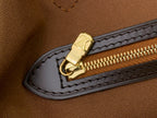 Zippered pocket edge with gold pull on brown monogram tote