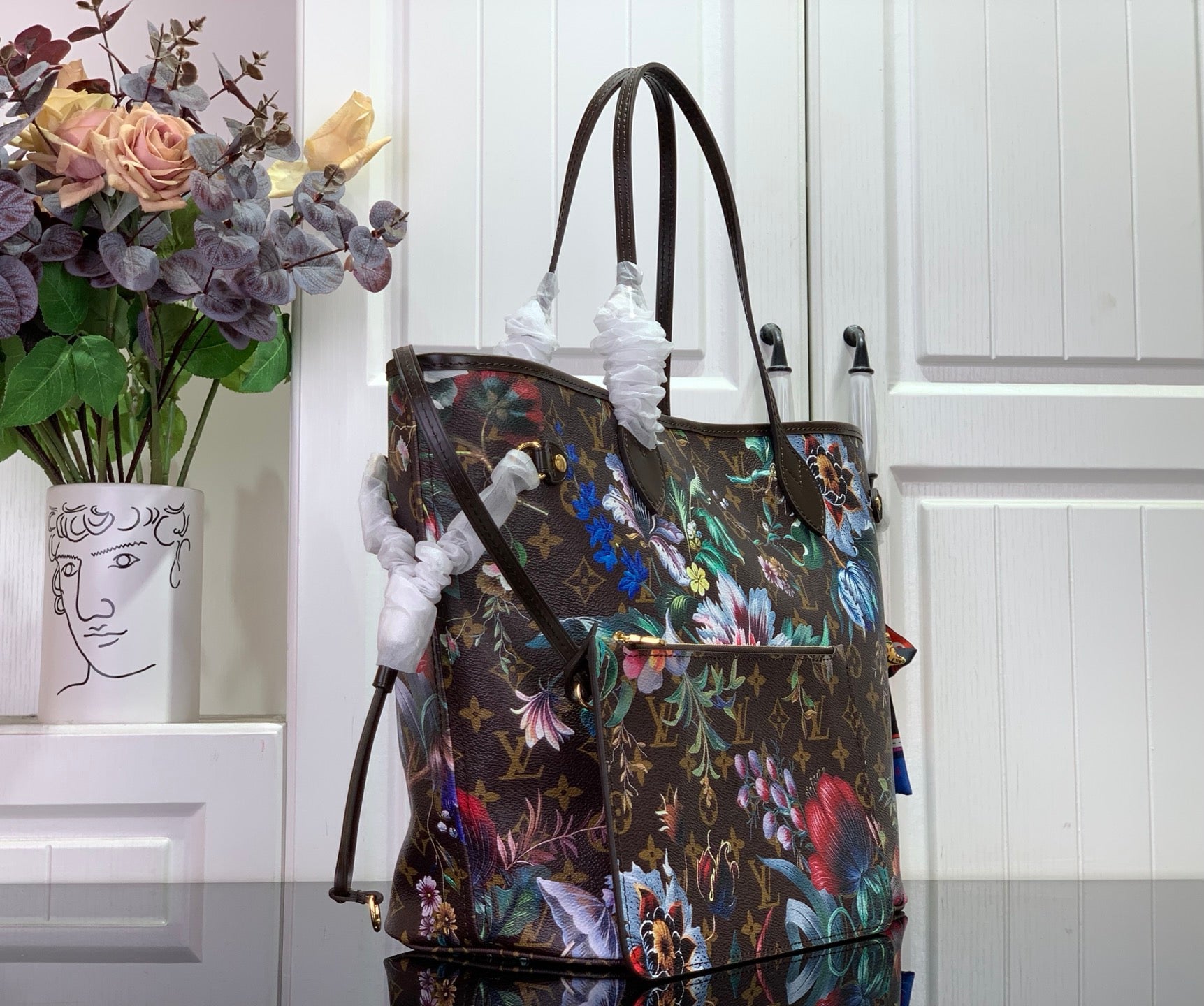 Louis Vuitton tote bag with colorful floral print, top handles, and side strap