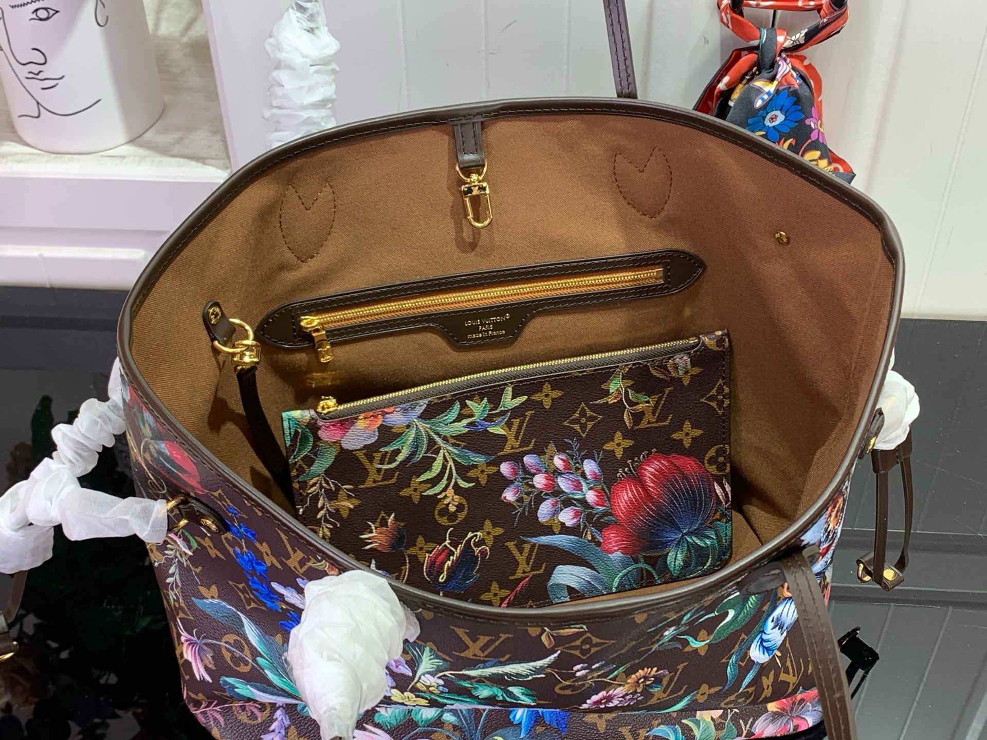 Louis Vuitton bag open top showing brown lining and floral zip pocket interior