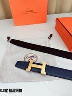 Dark blue leather belt with gold H buckle and dark leather underside on a pouch