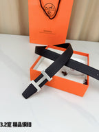 Leather belt with dark strap and gold-tone H buckle, crossed angled view.