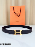 Leather belt with dark strap and gold-tone H buckle, shown flat with clasp centered.