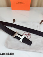 Dark leather belt with gold-tone H buckle, shown with strap ends and pouch.