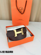 Dark brown leather belt with gold-tone H buckle, folded in gift box.