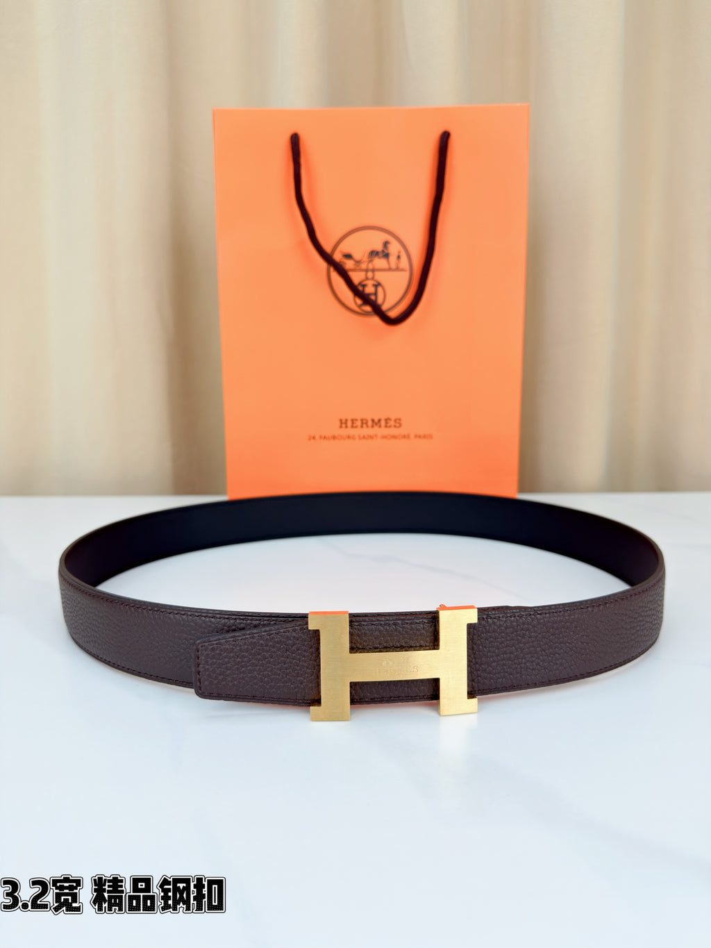 Dark brown leather belt with gold-tone H buckle, smooth strap.