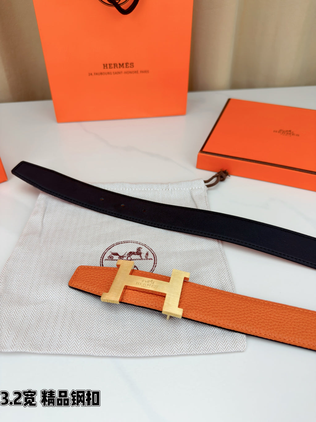 Two-tone belt with orange leather and black strap, metal H buckle on cloth