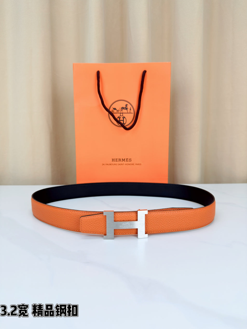 Orange leather belt with silver-tone H buckle, shown with gift box