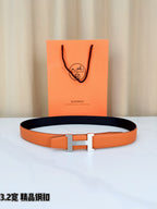 Orange leather belt with silver-tone H buckle, shown with gift box