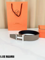 Grey leather belt with gold-tone H buckle, laid flat