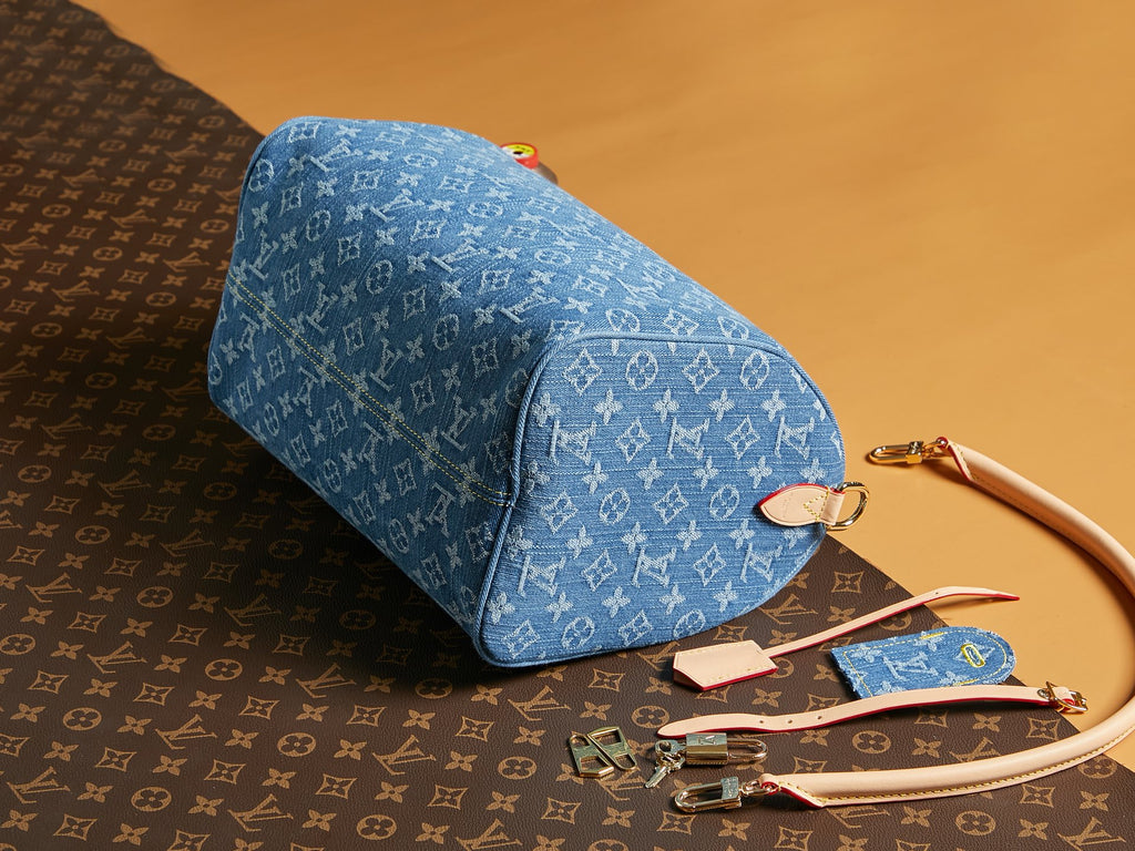 Blue Louis Vuitton monogram duffel-style bag with rolled handle and zip top.