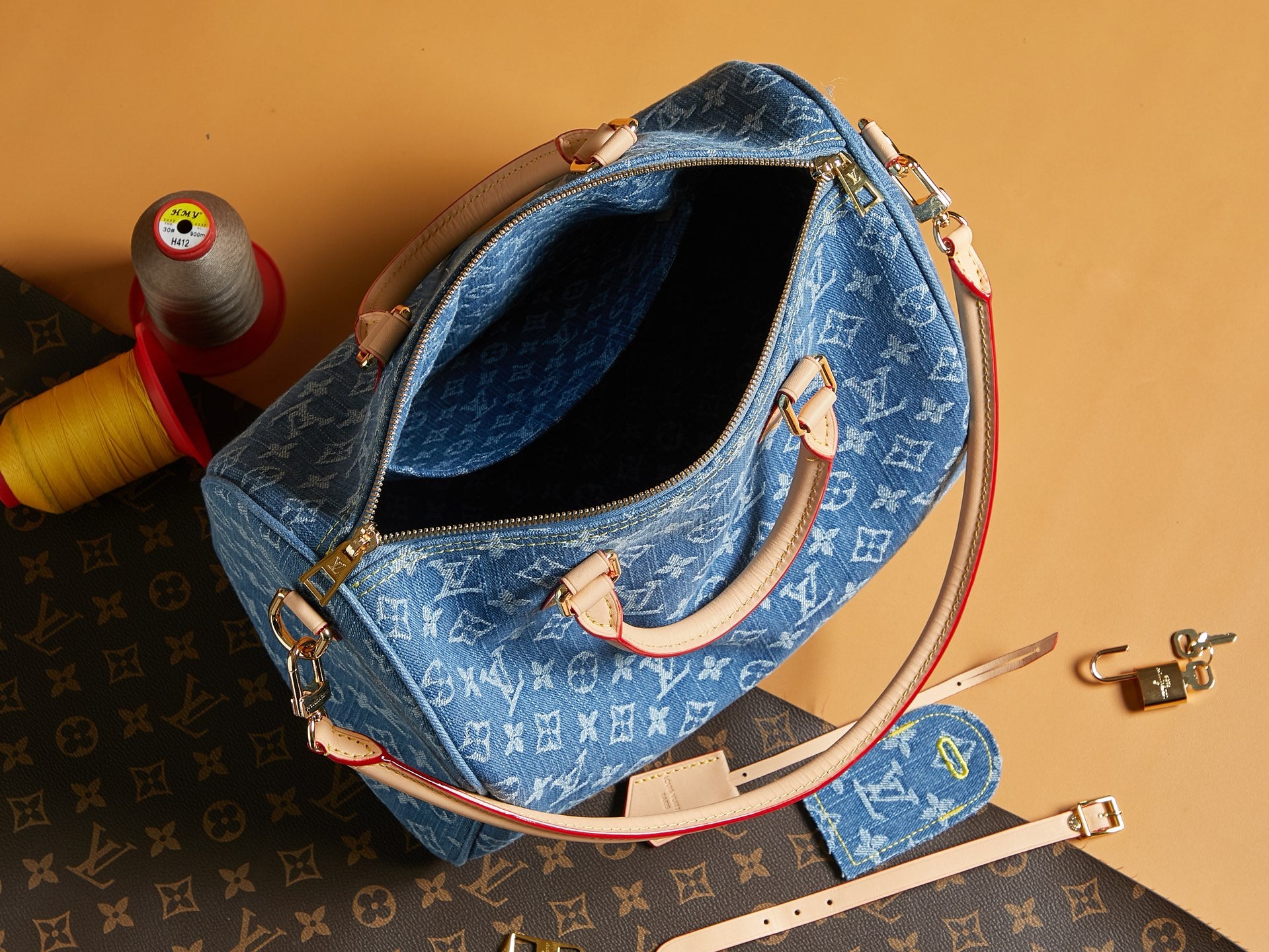 Blue Louis Vuitton monogram bag with open top view and cream trim.