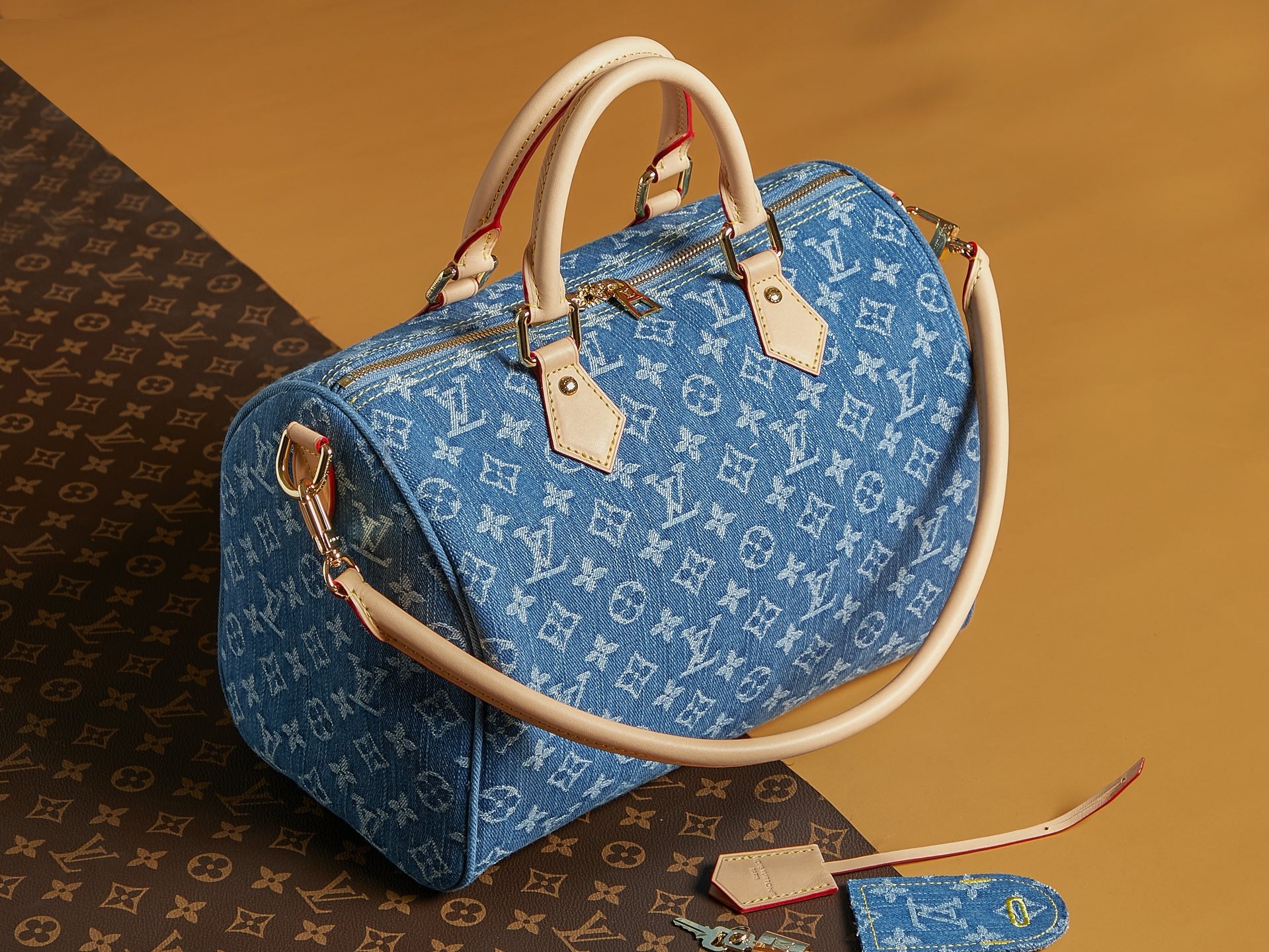 Blue Louis Vuitton monogram tote bag with cream handles and zip top.