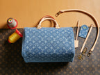 Blue Louis Vuitton monogram handbag with dual top handles and zippered top.