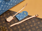 Blue Louis Vuitton monogram accessory set with wristlet and straps on bag.