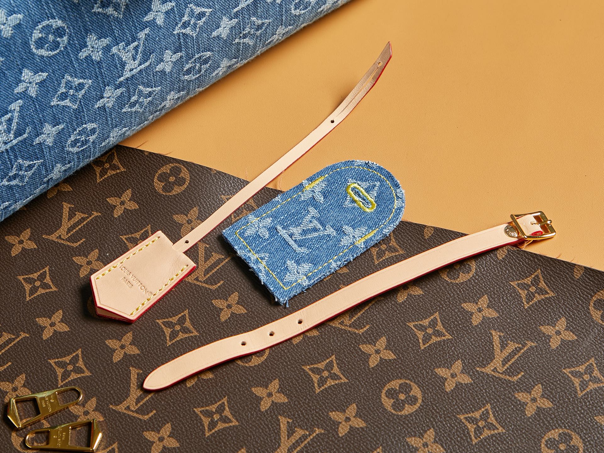 Blue Louis Vuitton monogram accessory set with wristlet and straps on bag.