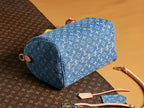 Blue Louis Vuitton monogram barrel bag with curved handle and top zipper.