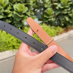 Black leather belt with punched sizing holes and gold-tone buckle hardware