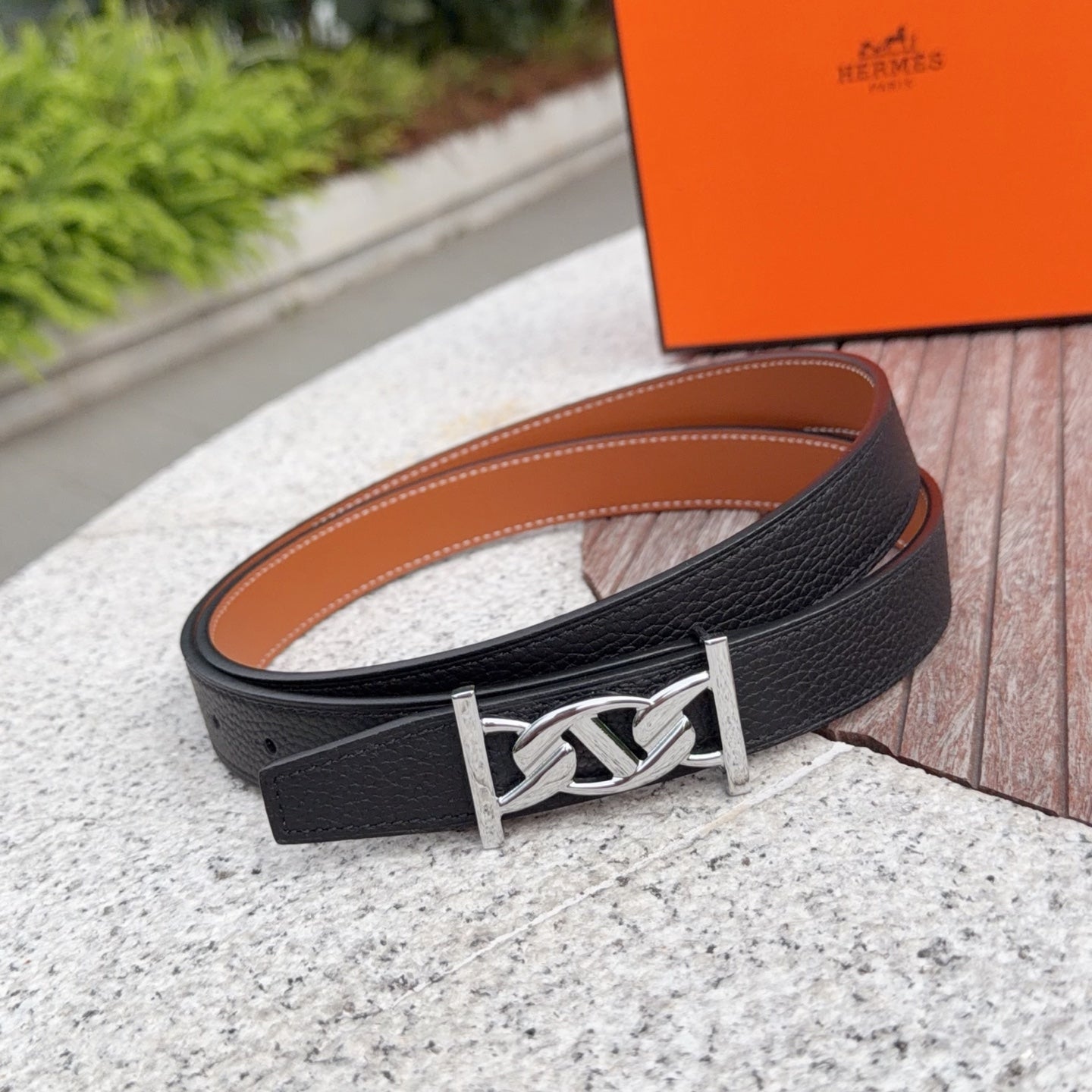 Black leather Hermes belt with tan underside and silver-tone interlocking buckle