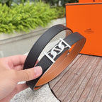 Black leather Hermes belt with silver-tone buckle and tan interior edge