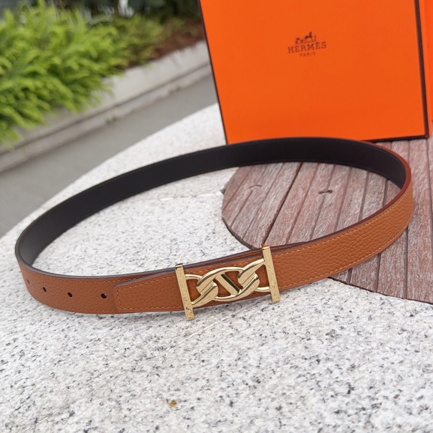 Hermes belt in tan leather with gold-toned buckle and single keeper, flat lay