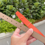 Leather belt with tan and orange straps, gold buckle, visible adjustment holes