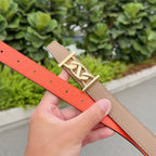 Leather belt with orange strap and tan underside, gold buckle and punched holes