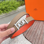 Leather belt close-up: tan textured leather, silver buckle, and orange lining