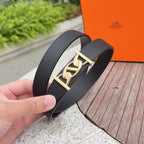 Textured leather belt with dark strap and gold-toned buckle in hand