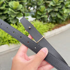 Leather belt with dark gray strap, gold-toned hardware, and hole row