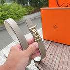 Taupe leather belt with gold buckle, slim profile, and topstitched edges