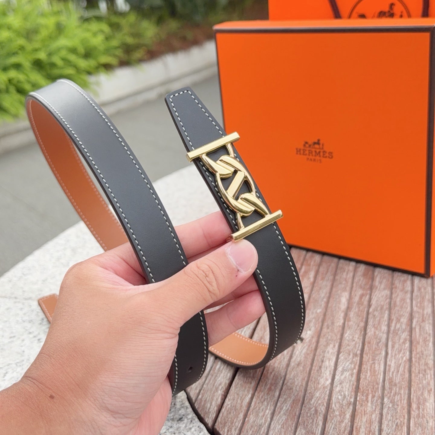 Leather belt with gold-tone buckle, dark blue outer strap and tan underside