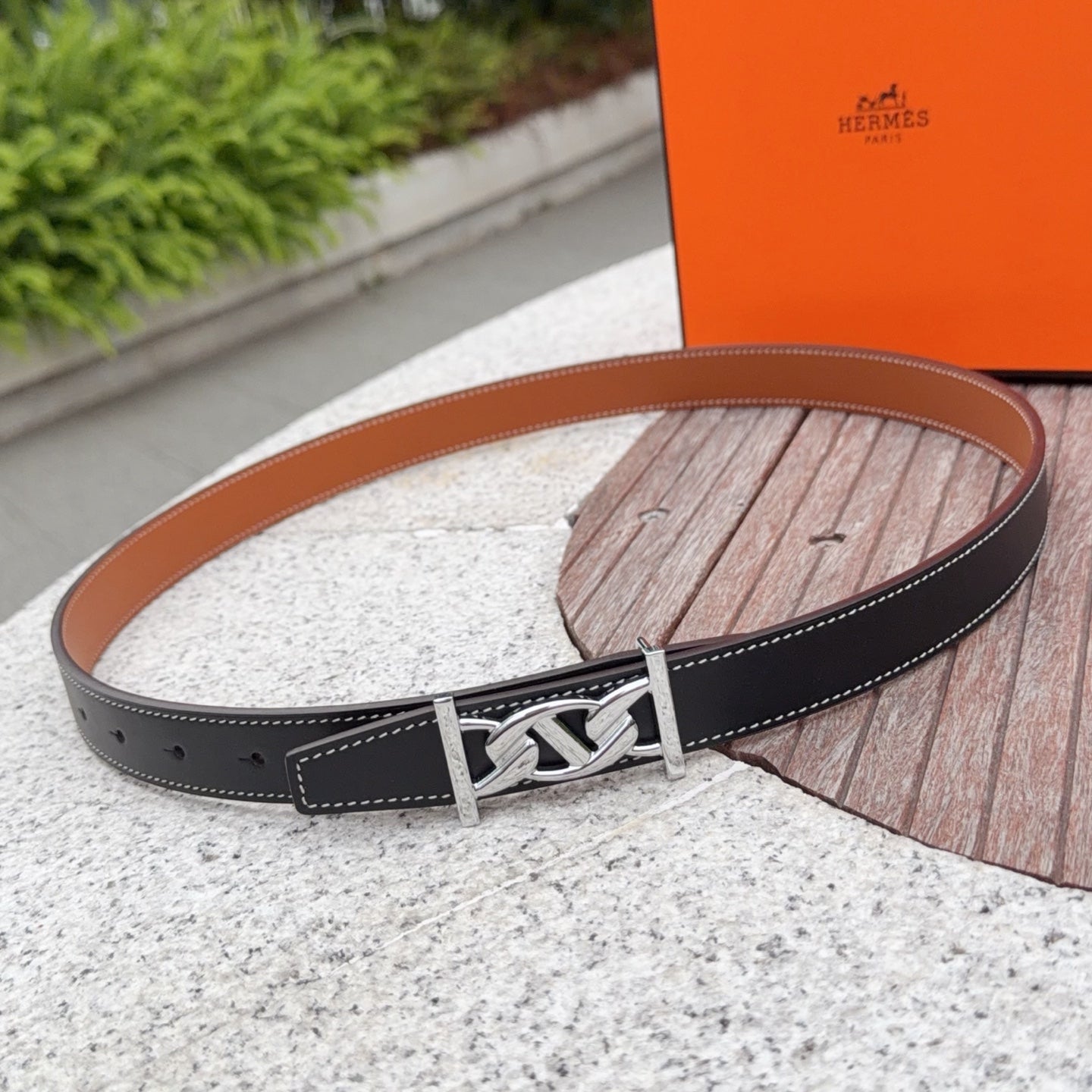 Black leather belt with silver buckle and stitched edges, plus row of holes