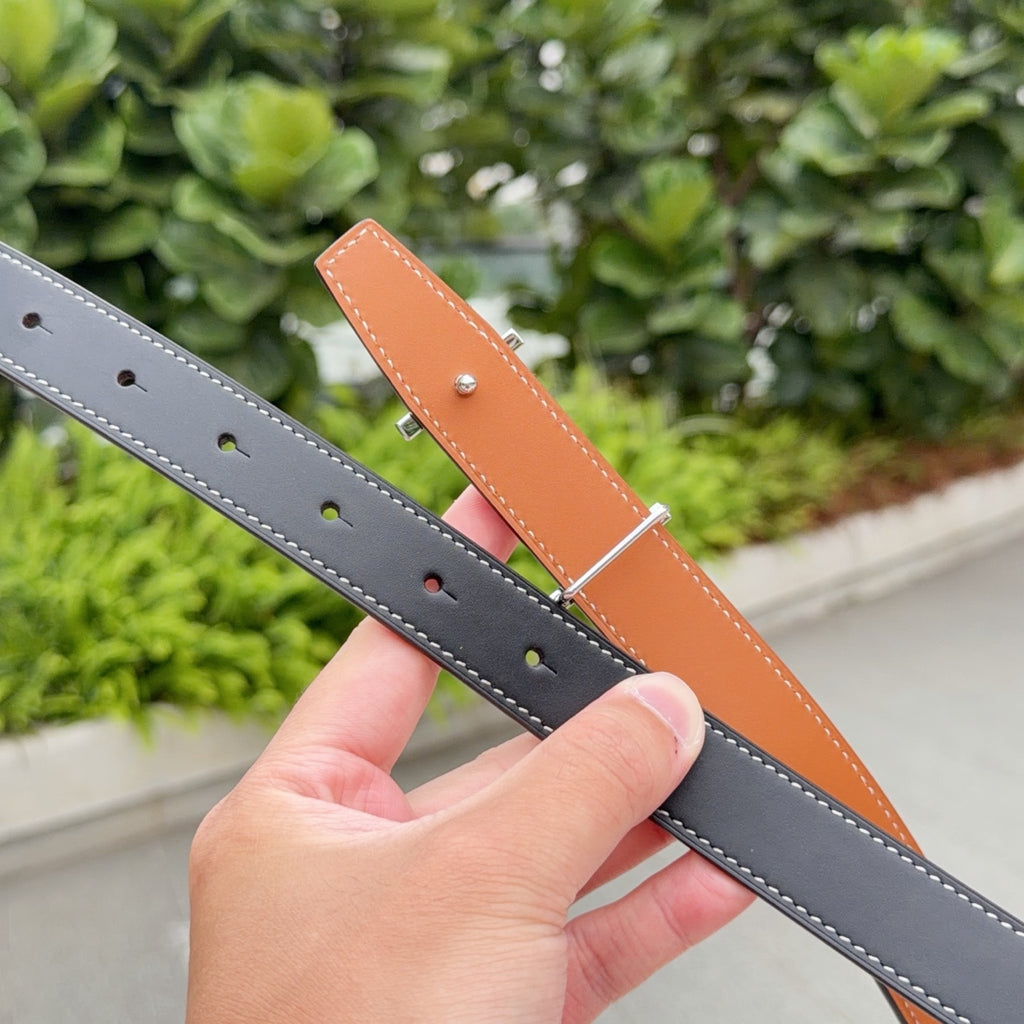 Leather belts in dark gray and tan, each with punched holes and white stitching