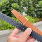 Leather belt with tan and dark straps, gold hardware, and row of adjustment holes