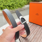 Hermes belt on hand view, dark strap with silver buckle and tan underside