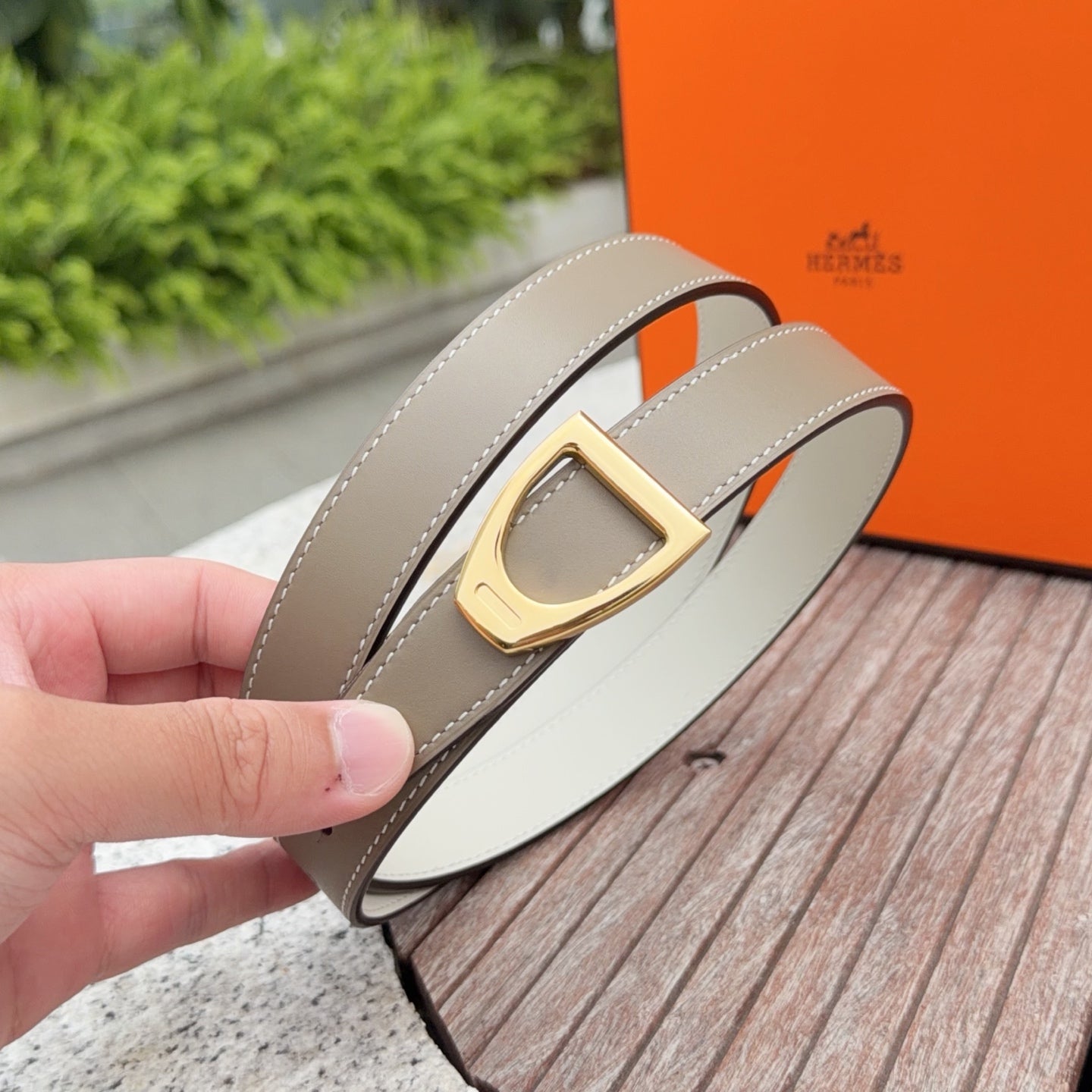 Taupe leather Hermes belt buckle close-up with gold-tone square clasp