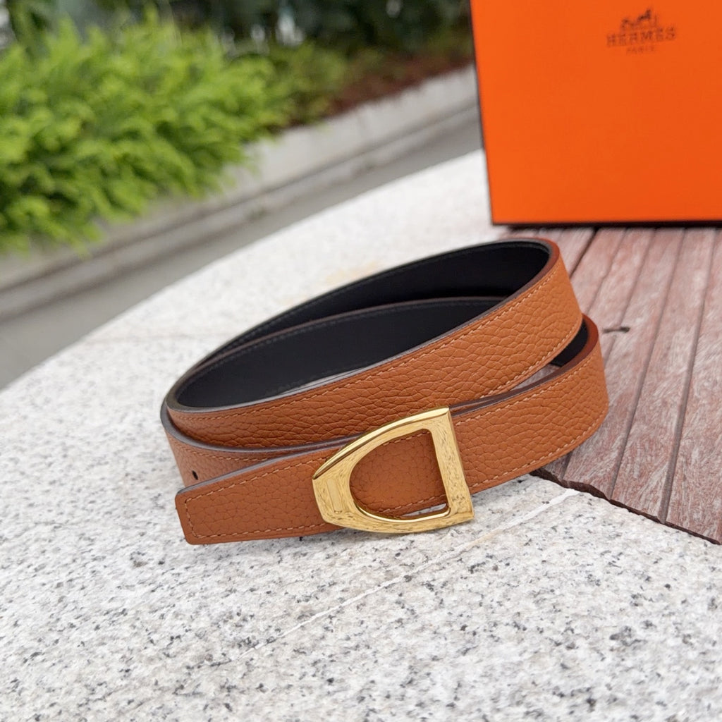 Leather belt with tan strap, black underside, and gold rectangular buckle.